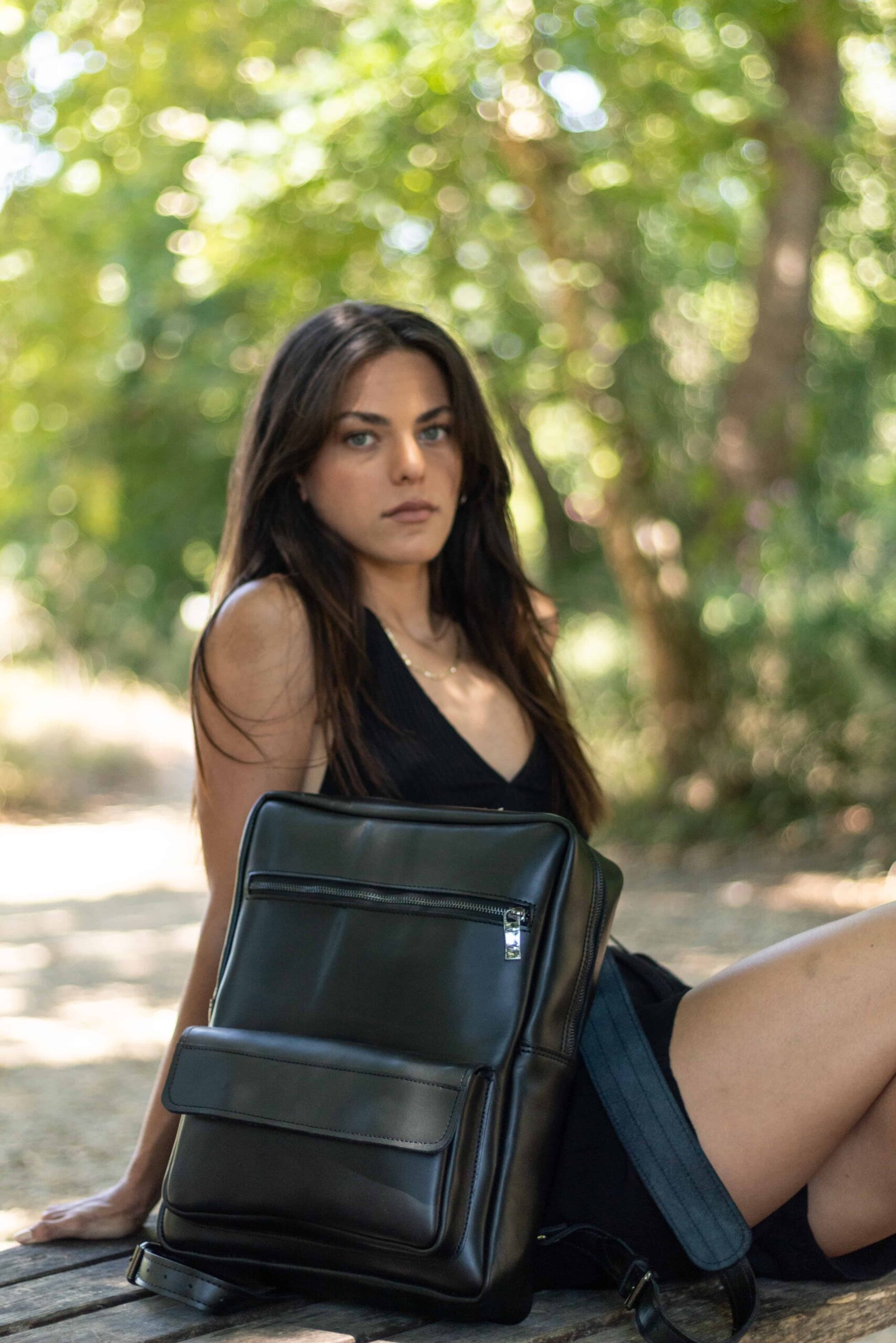 a model wearing our black leather backpack